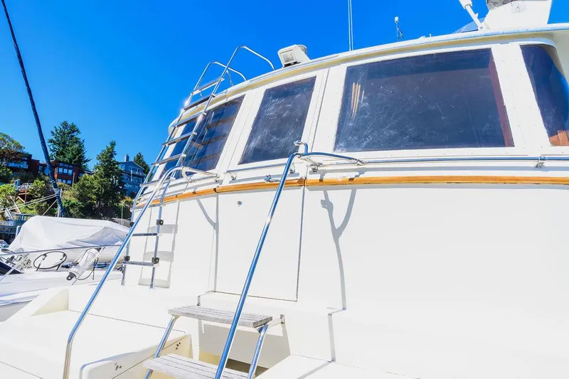 Slide: The Image of 1987 Hatteras 72 Flush Deck Cockpit Motor Yacht, exterior view with ladder and windows. - 14