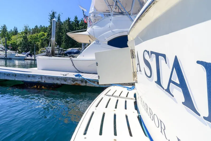 Slide: The Image of 1987 Hatteras 72 Flush Deck Cockpit Motor Yacht docked in a scenic marina. - 16