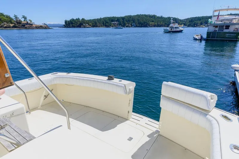 Slide: The Image of 1987 Hatteras 72 Flush Deck Cockpit Motor Yacht on serene water with scenic backdrop. - 17