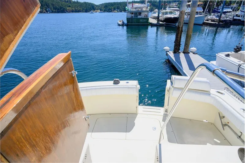 Slide: The Image of 1987 Hatteras 72 Flush Deck Cockpit Motor Yacht docked in a scenic marina. - 19