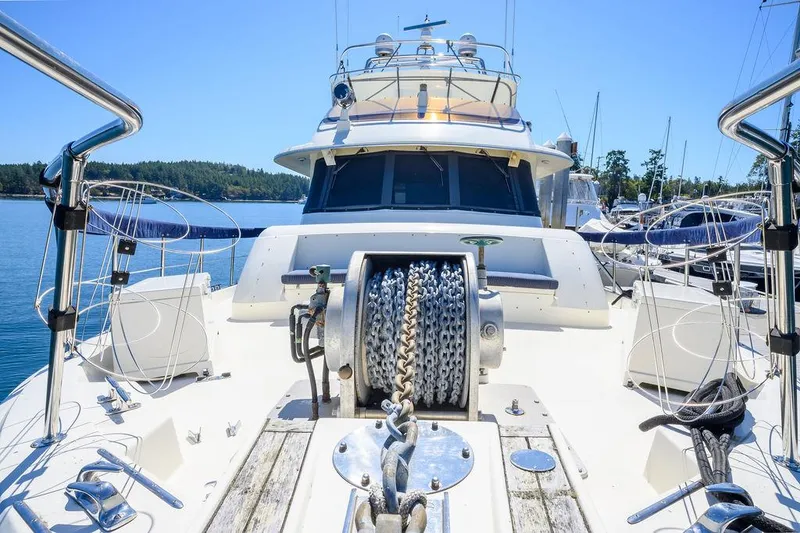 Slide: The Image of 1987 Hatteras 72 Flush Deck Cockpit Motor Yacht anchored in a serene marina. - 21