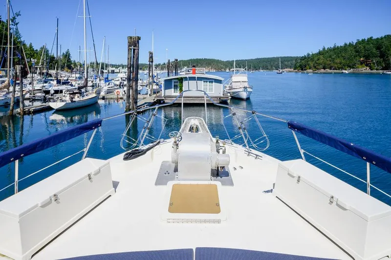 Slide: The Image of 1987 Hatteras 72 Flush Deck Cockpit Motor Yacht docked in a scenic marina. - 25