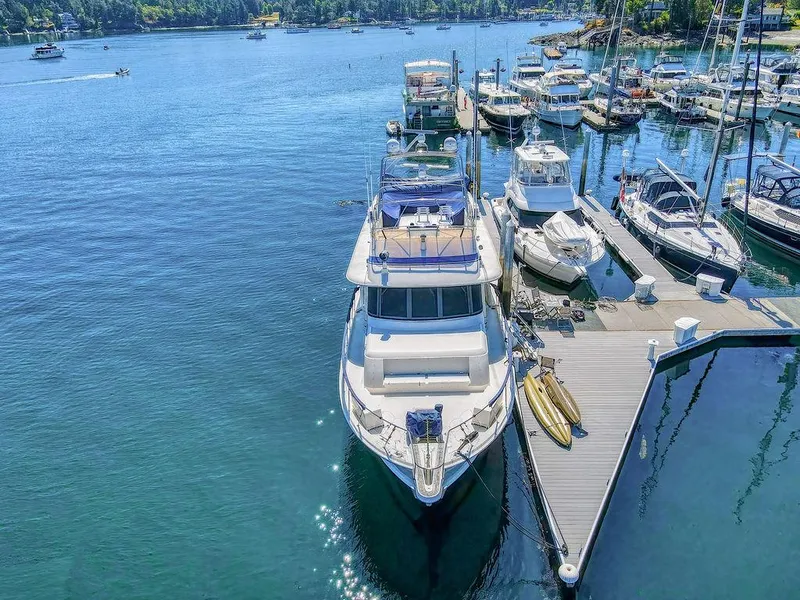 Slide: The Image of 1987 Hatteras 72 Flush Deck Cockpit Motor Yacht docked in a serene marina. - 3