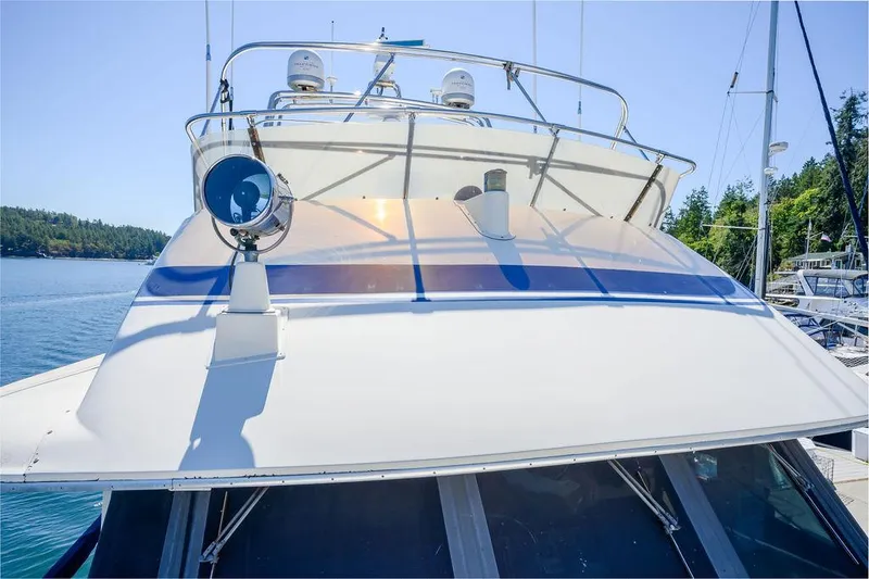 Slide: The Image of 1987 Hatteras 72 Flush Deck Cockpit Motor Yacht docked in a serene marina. - 34