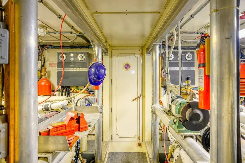 Slide: The Image of Engine room of 1987 Hatteras 72 Flush Deck Cockpit Motor Yacht, featuring equipment and safety gear. - 36