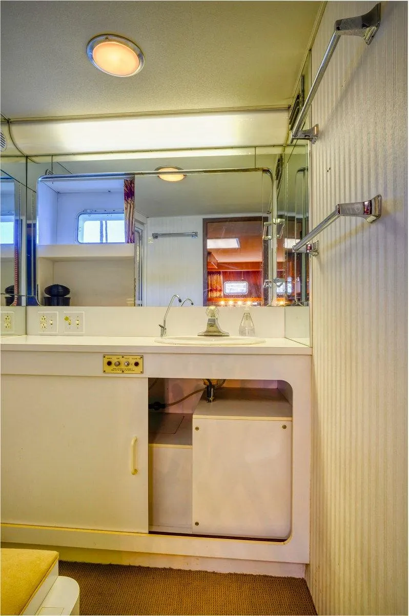 Slide: The Image of Bathroom interior of 1987 Hatteras 72 Flush Deck Cockpit Motor Yacht, featuring mirrored walls and modern fixtures. - 44