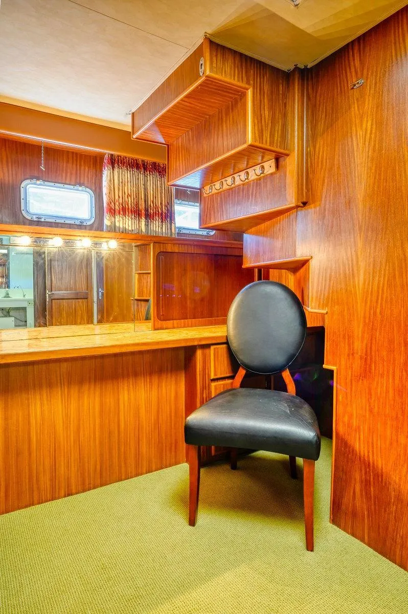 Slide: The Image of Interior of 1987 Hatteras 72 Yacht with wooden desk and black chair. - 45