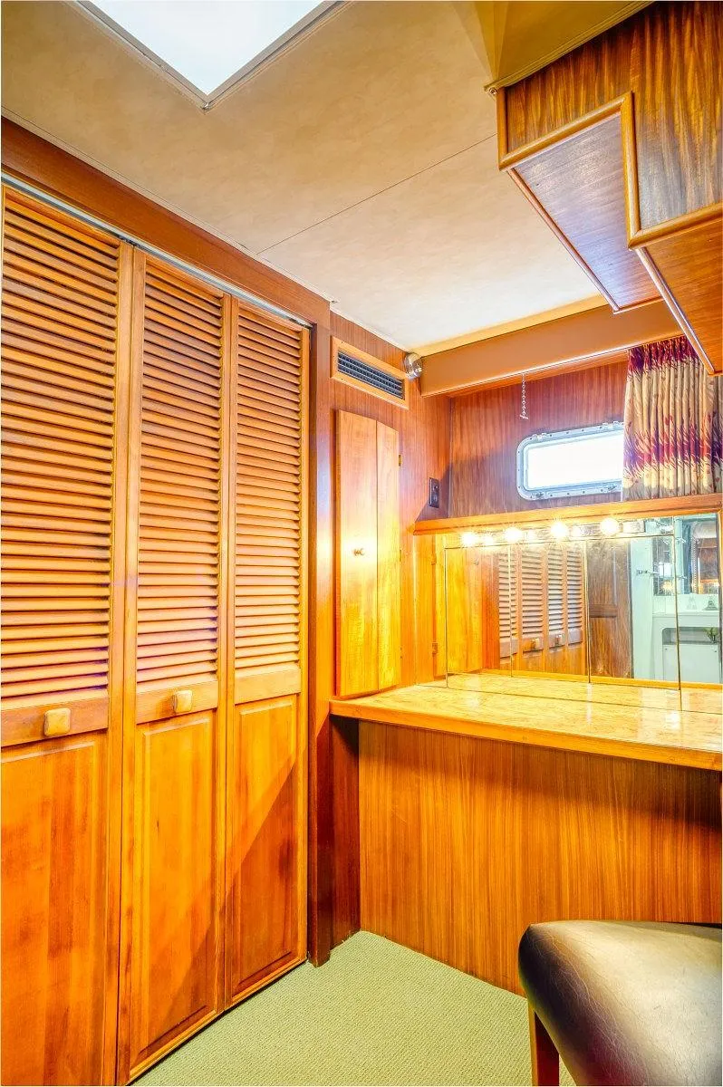 Slide: The Image of 1987 Hatteras 72 Yacht interior with wooden cabinetry and seating area. - 46