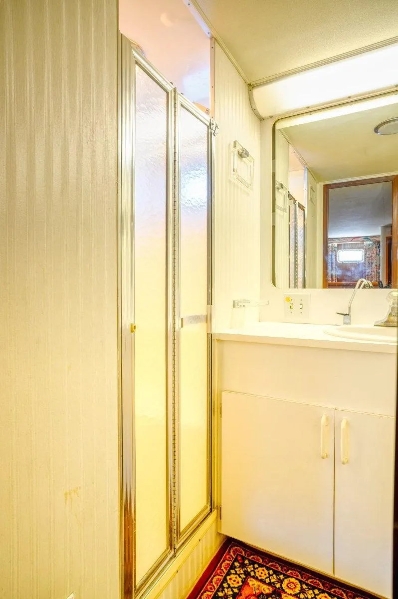 Slide: The Image of 1987 Hatteras 72 yacht bathroom with shower, vanity, and mirror. - 49