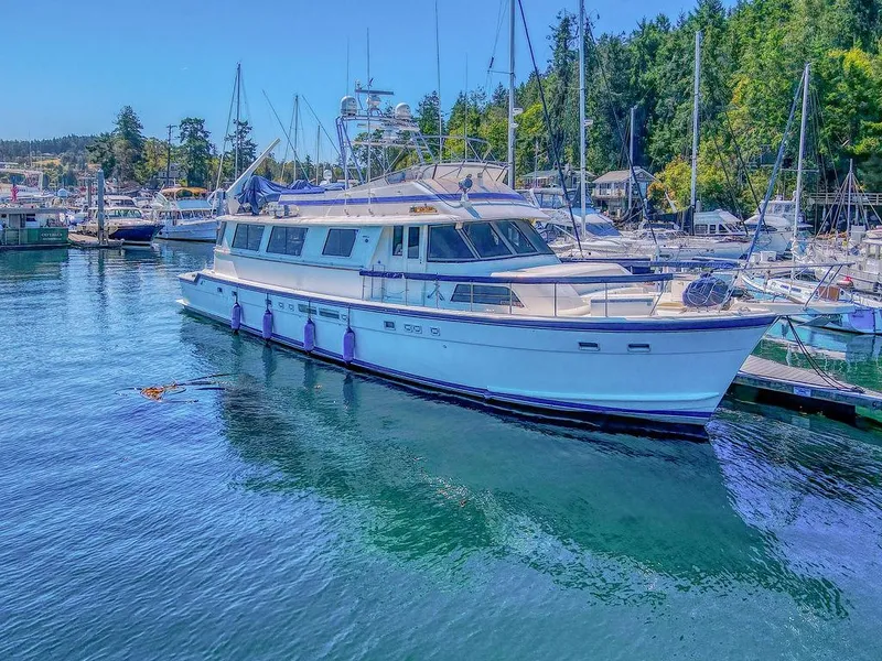 Slide: The Image of 1987 Hatteras 72 Flush Deck Cockpit Motor Yacht docked in a scenic marina. - 6