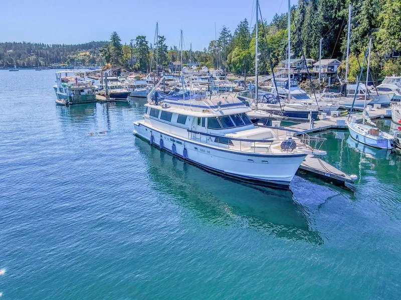 Slide: The Image of 1987 Hatteras 72 Flush Deck Cockpit Motor Yacht docked in a scenic marina. - 7