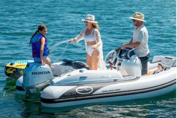 Slide: The Image of Family enjoying a day on a 2025 Walker Bay Generation 12 boat in sunny weather. - 7
