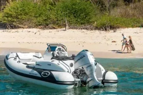 Slide: The Image of Walker Bay Generation 12 boat, 2025 model, anchored near a sandy beach with people walking. - 9