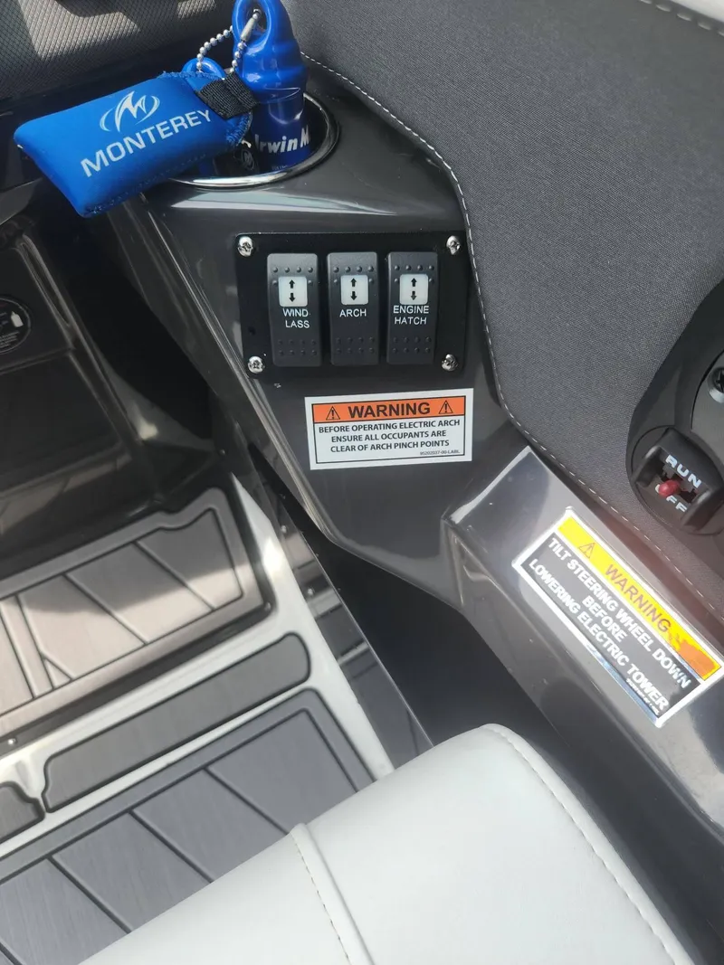 Slide: The Image of Control panel of a 2022 Monterey 278SS boat with warning labels and keychain. - 20