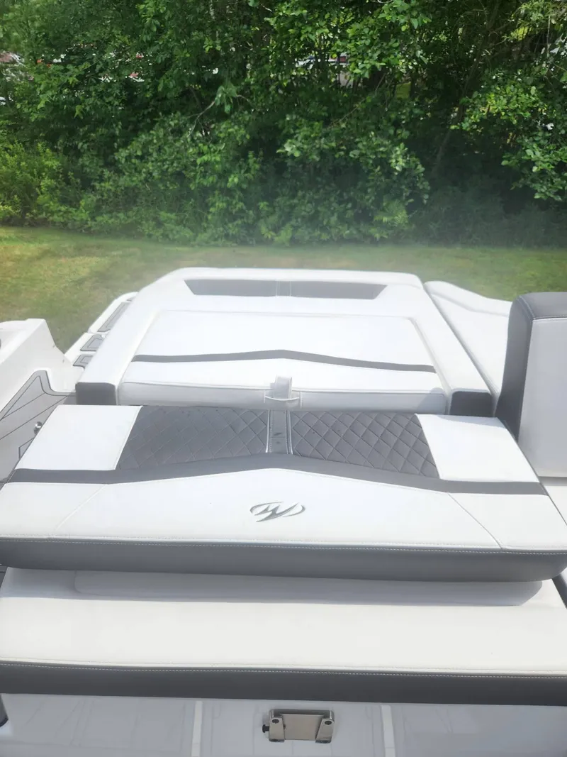 Slide: The Image of 2022 Monterey 278SS boat with white and black seating, lush green background. - 23