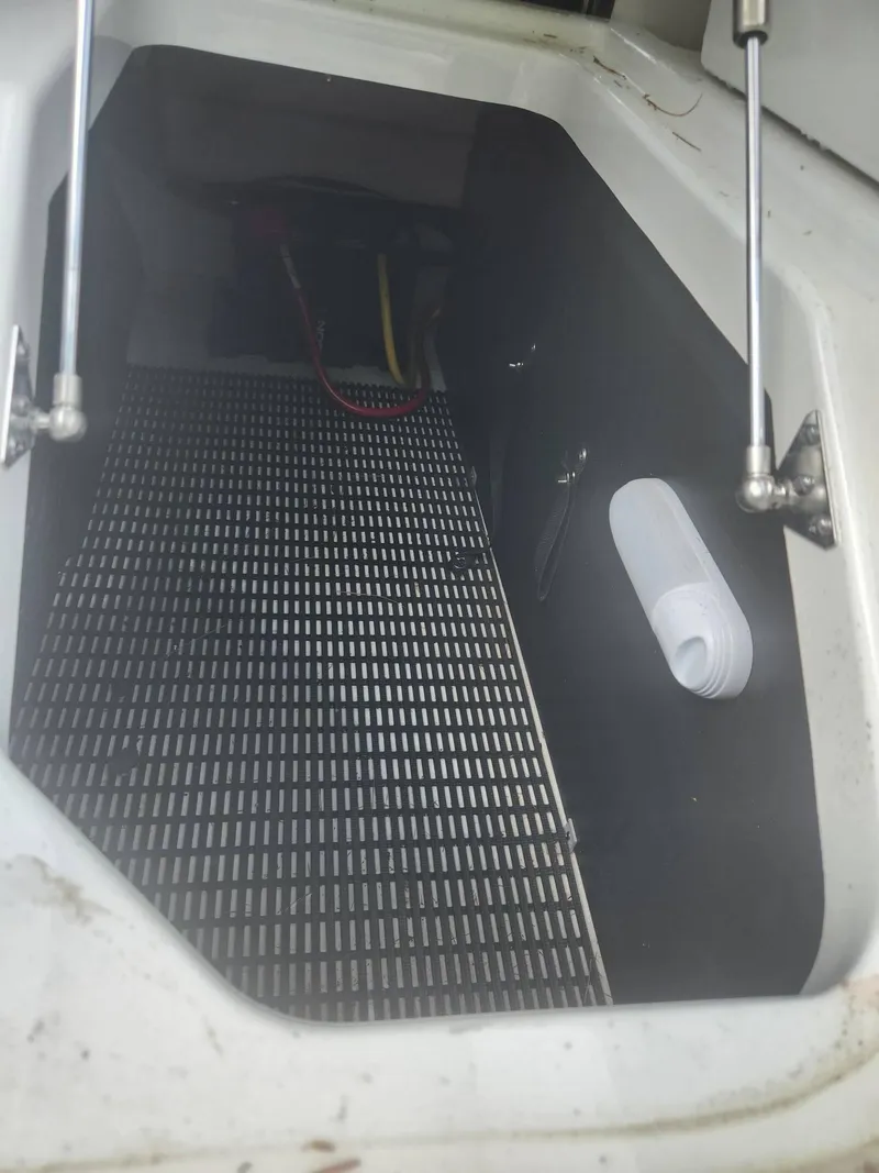 Slide: The Image of 2022 Monterey 278SS boat storage compartment with grid flooring and hydraulic struts. - 25