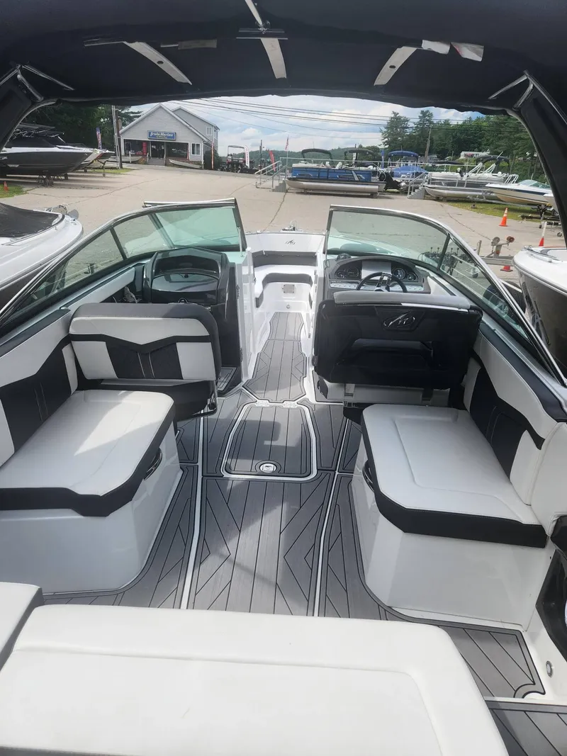 Slide: The Image of Interior of 2022 Monterey 278SS boat with seating and dashboard, docked at a marina. - 5