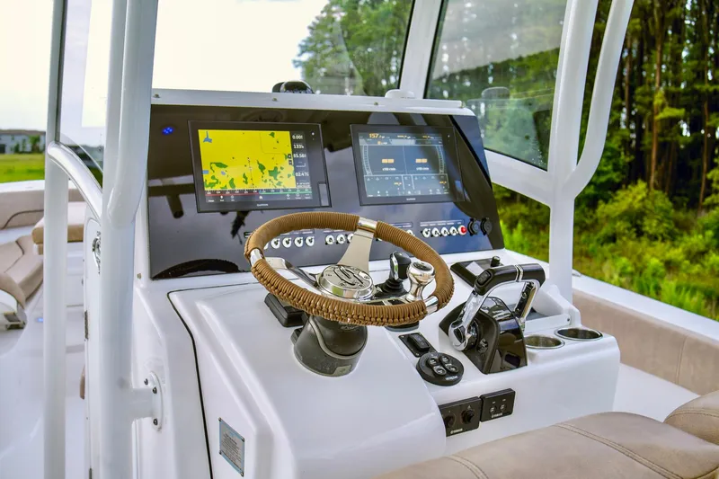 Slide: The Image of 2019 Sportsman Open 282 Center Console boat dashboard with navigation screens and controls. - 16
