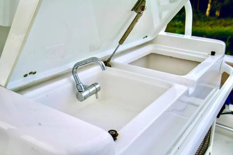 Slide: The Image of 2019 Sportsman Open 282 Center Console sink and storage compartments. - 19