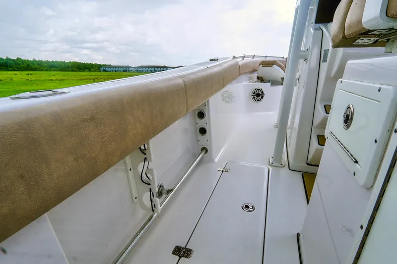 Slide: The Image of 2019 Sportsman Open 282 Center Console boat interior with cushioned seating and storage compartments. - 21