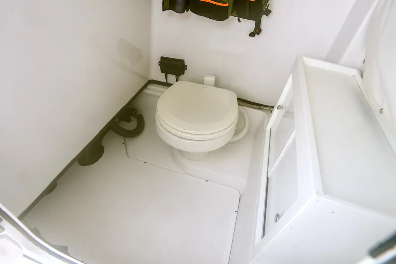 Slide: The Image of 2019 Sportsman Open 282 Center Console boat interior with toilet and storage. - 23