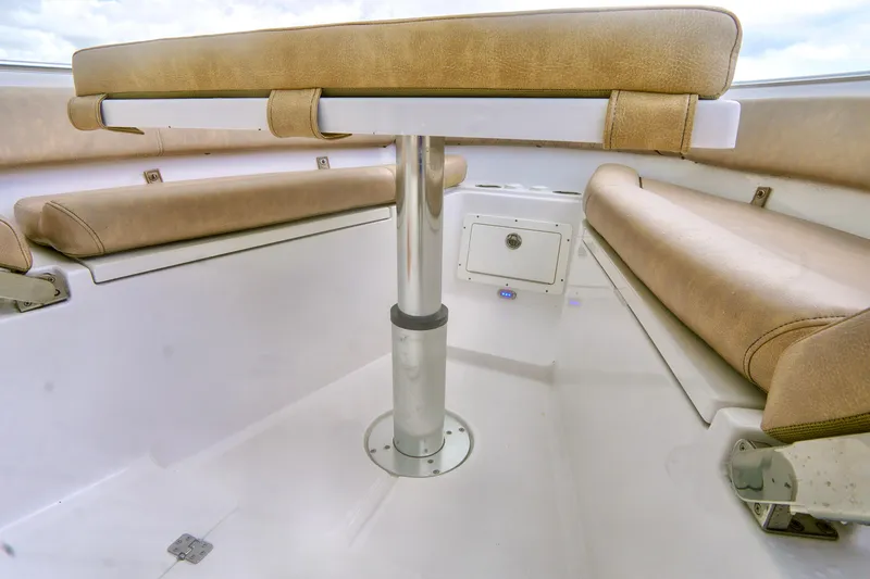 Slide: The Image of 2019 Sportsman Open 282 Center Console boat interior with cushioned seating and table. - 7