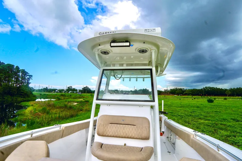 Slide: The Image of 2019 Sportsman Open 282 Center Console boat with seating and lush green landscape. - 9