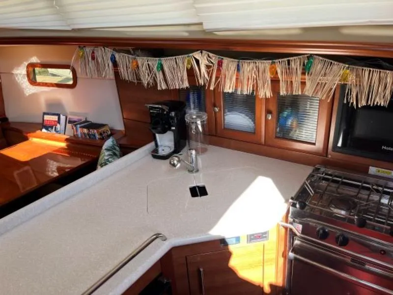 Slide: The Image of Interior of 2012 Hunter 36E sailboat kitchen with stove, counter, and festive decor. - 11