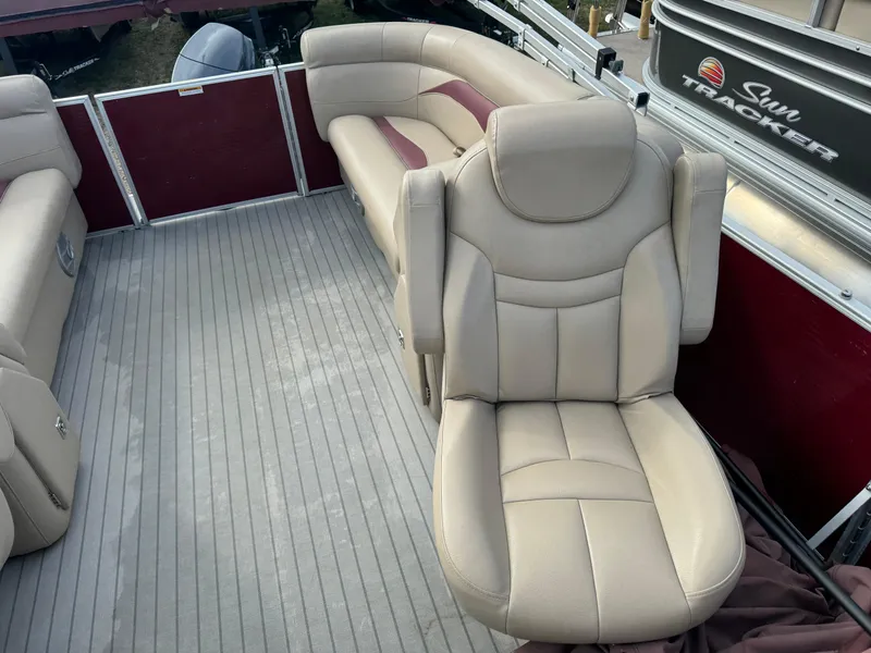Slide: The Image of 2016 Godfrey Sweet Water boat interior with beige leather seating and gray flooring. - 11
