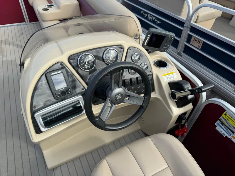 Slide: The Image of 2016 Godfrey Sweet Water boat dashboard with steering wheel and navigation instruments. - 17