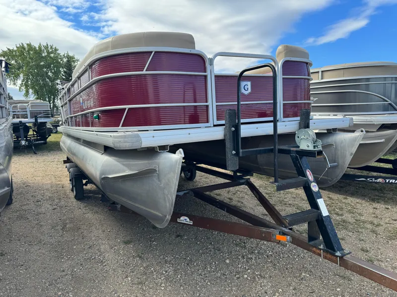 Slide: The Image of 2016 Godfrey Sweet Water pontoon boat on trailer, red exterior, parked outdoors. - 2
