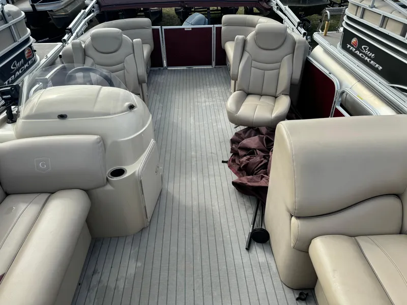 Slide: The Image of 2016 Godfrey Sweet Water boat interior with beige seating and steering console. - 8