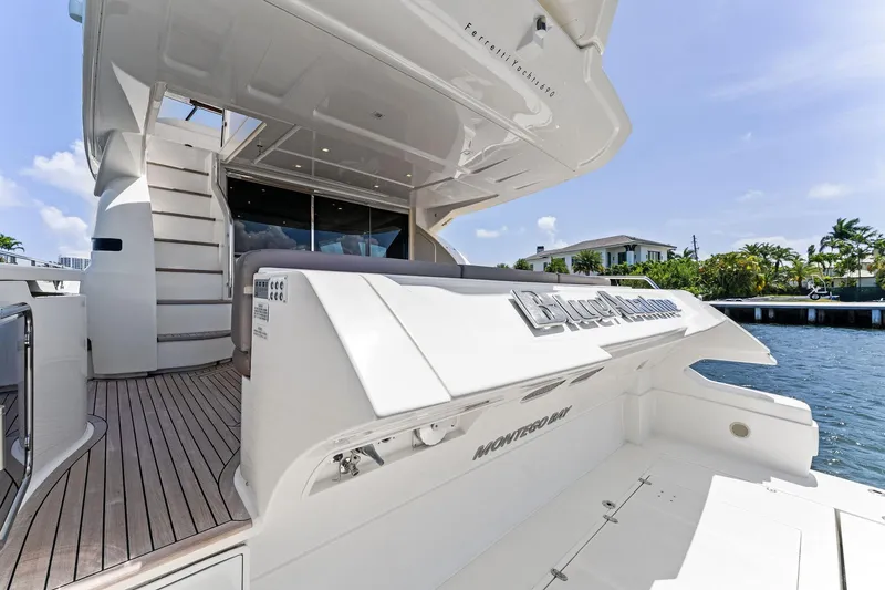 Slide: The Image of 2015 Ferretti Yachts 690, luxury yacht docked by waterfront, showcasing sleek design and spacious deck. - 21