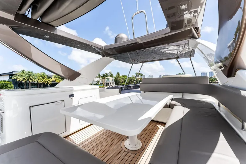 Slide: The Image of Luxurious 2015 Ferretti Yachts 690 flybridge with elegant seating and table, under a sunny sky. - 27