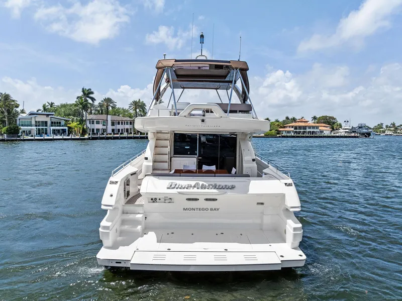 Slide: The Image of 2015 Ferretti Yachts 690 on water, rear view, sunny day, luxury waterfront homes. - 7