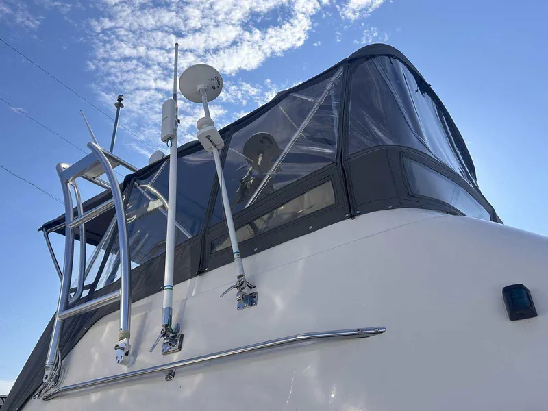 Slide: The Image of 1987 Silverton 40 Double Cabin boat with clear canopy under blue sky. - 11