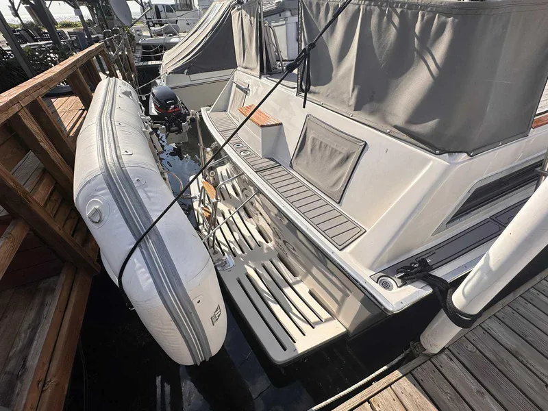 Slide: The Image of 1987 Silverton 40 Double Cabin yacht with attached inflatable boat at dock. - 12