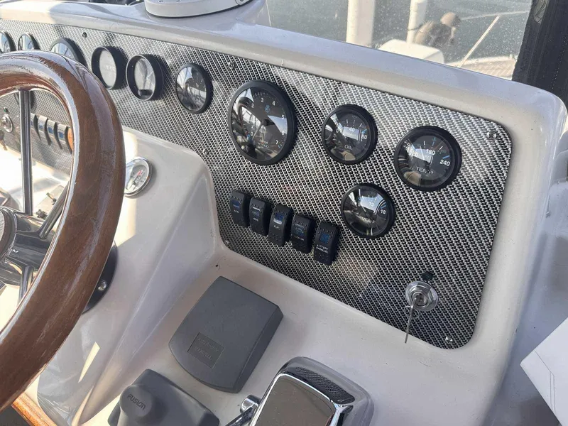 Slide: The Image of 1987 Silverton 40 Double Cabin dashboard with gauges and controls, featuring a wooden steering wheel. - 23