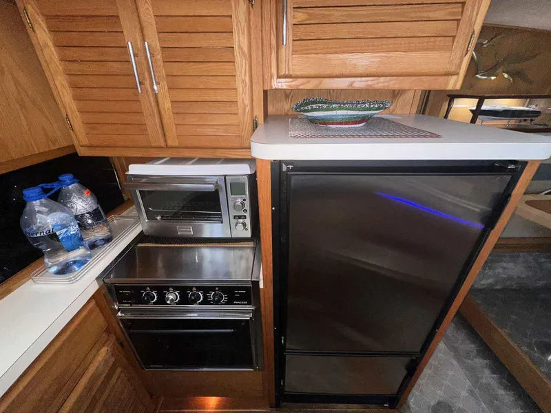 Slide: The Image of 1987 Silverton 40 Double Cabin kitchen with oven, fridge, and wooden cabinets. - 32