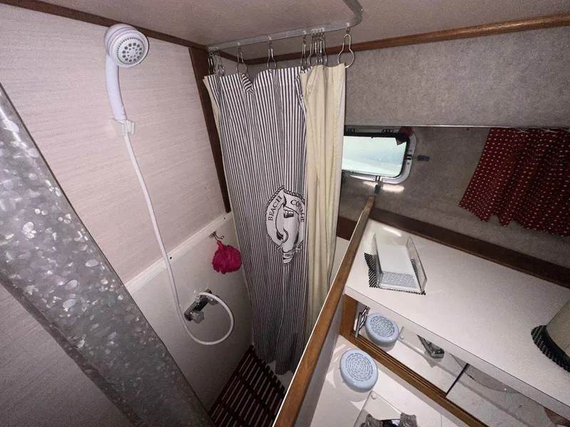 Slide: The Image of 1987 Silverton 40 Double Cabin bathroom with shower, curtain, and storage. - 34