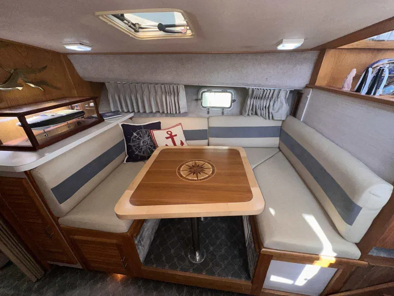 Slide: The Image of 1987 Silverton 40 Double Cabin interior with cozy dining area and nautical-themed decor. - 38