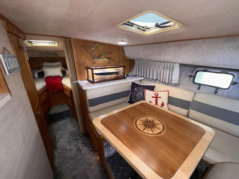 Slide: The Image of 1987 Silverton 40 Double Cabin interior with dining area, nautical decor, and cozy sleeping quarters. - 39