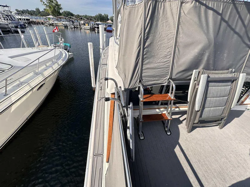 Slide: The Image of 1987 Silverton 40 Double Cabin yacht docked at marina, featuring deck and seating area. - 4