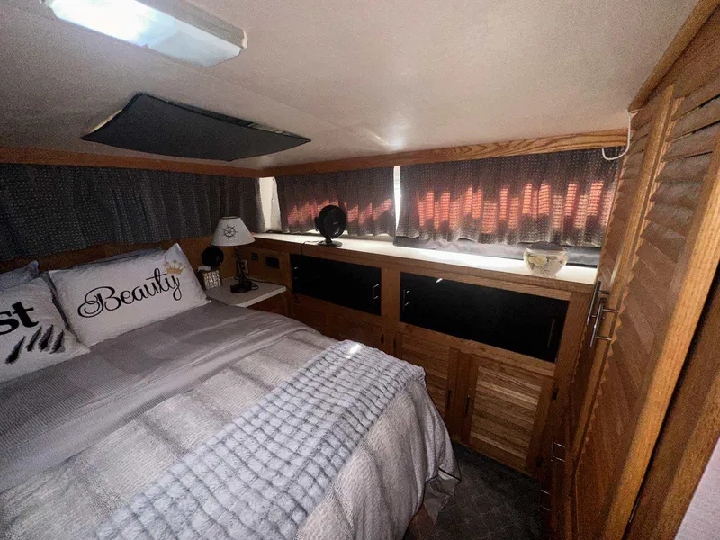 Slide: The Image of Cozy cabin bedroom in 1987 Silverton 40 Double Cabin boat with wood accents and soft lighting. - 41