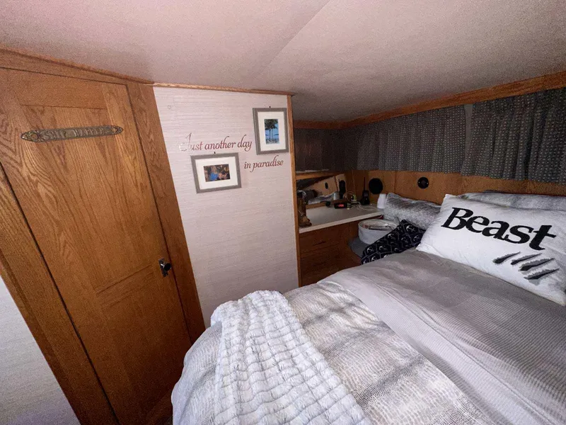 Slide: The Image of Cozy cabin bedroom in 1987 Silverton 40 Double Cabin boat, featuring wood accents and nautical decor. - 42