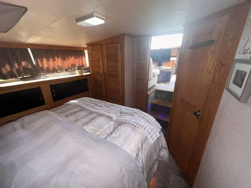 Slide: The Image of 1987 Silverton 40 Double Cabin interior with cozy bedroom and wooden cabinetry. - 45