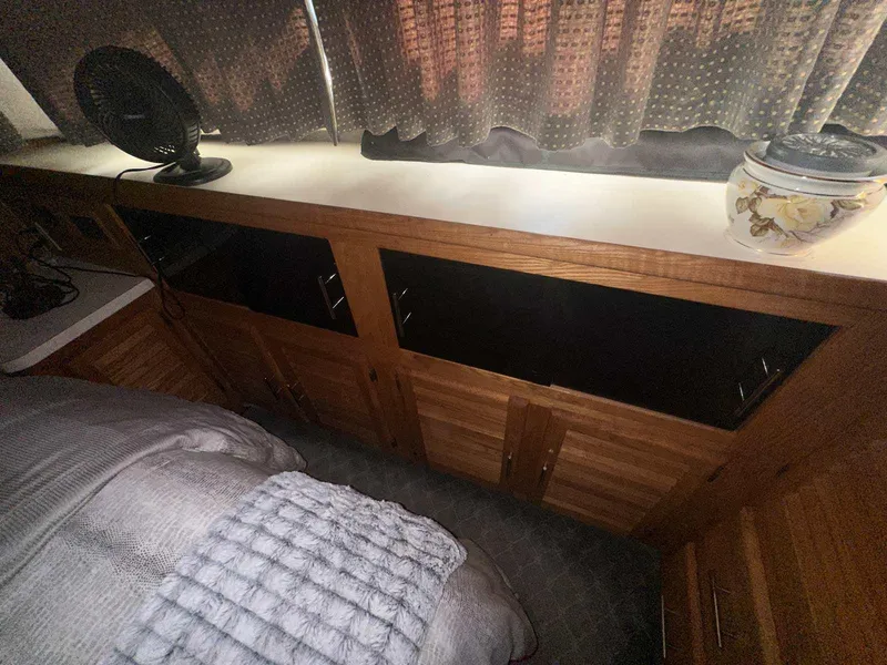 Slide: The Image of 1987 Silverton 40 Double Cabin interior with wooden cabinets and cozy bedding. - 49