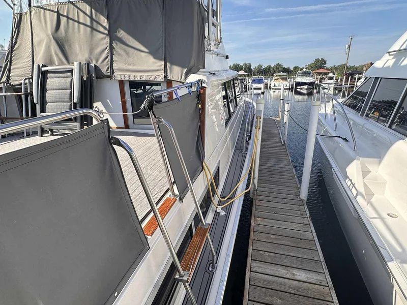 Slide: The Image of 1987 Silverton 40 Double Cabin yacht docked at marina, side view with walkway. - 5