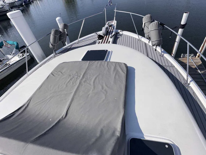 Slide: The Image of 1987 Silverton 40 Double Cabin yacht deck with gray cover, docked at marina. - 9