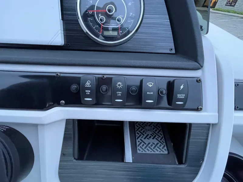 Slide: The Image of Control panel of 2024 Godfrey Sweetwater 2086 BF boat with various switches and a gauge. - 11